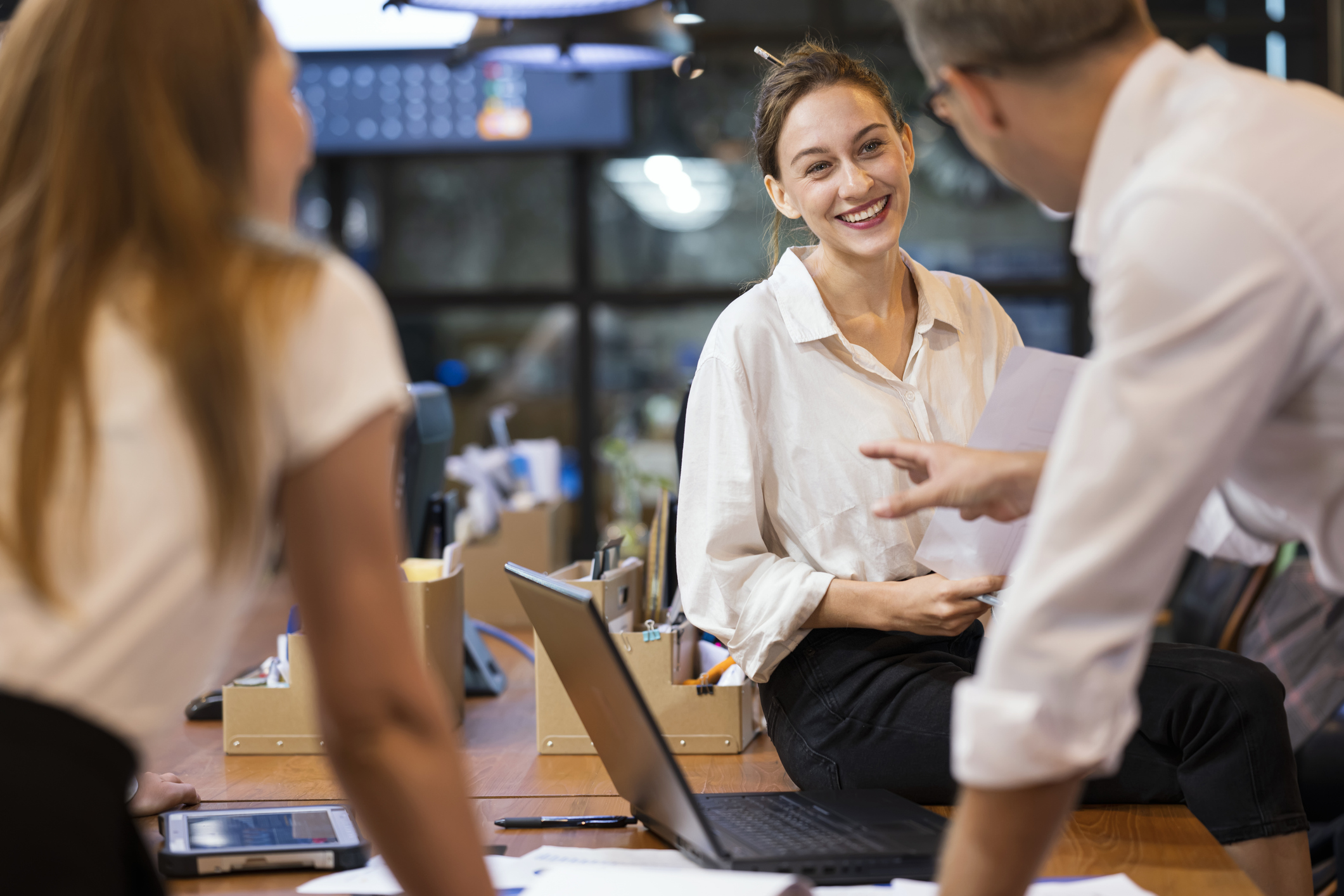 Woman looking at a group of people in an office smiling