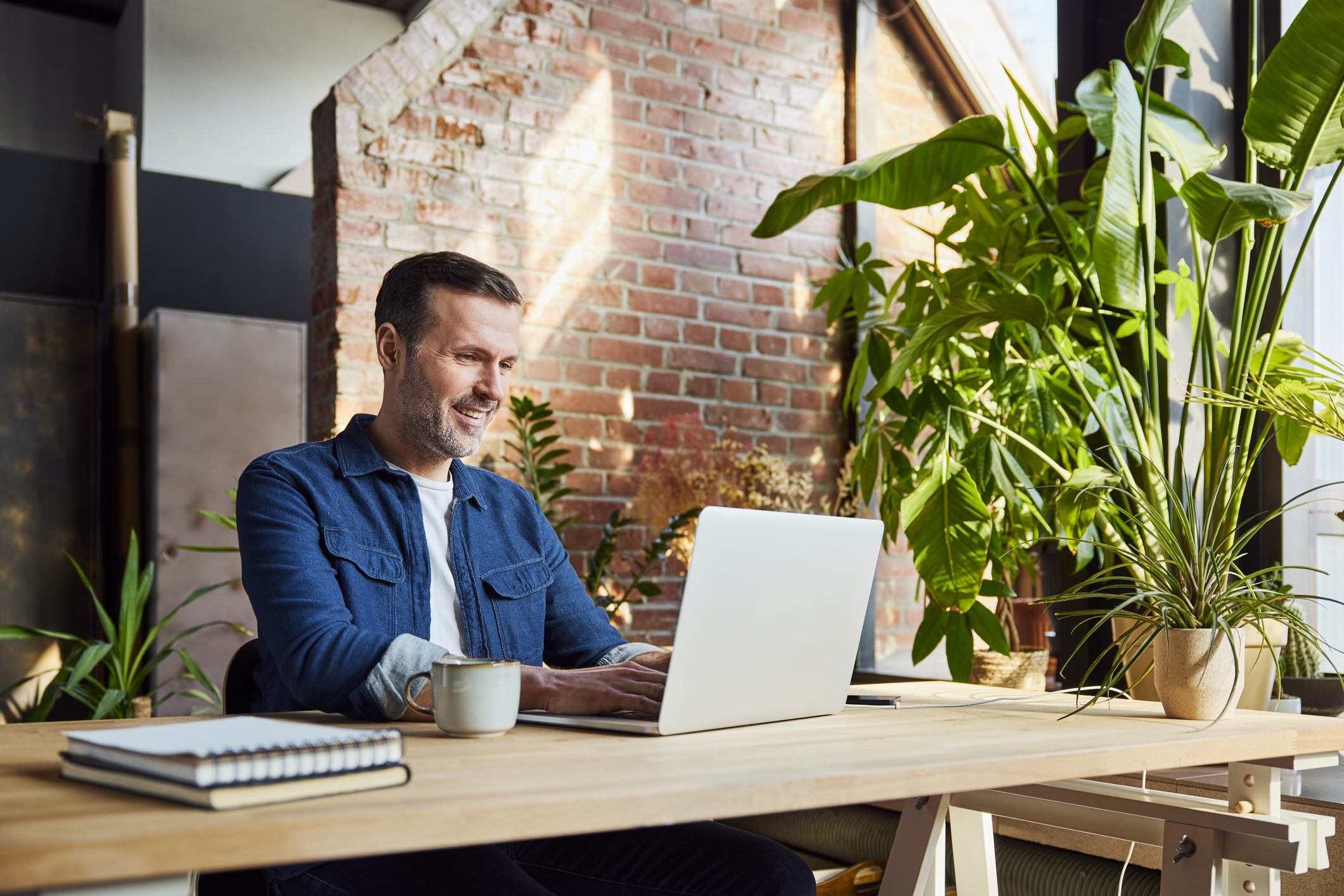 Man smiling sitting at a desk looking at his computer