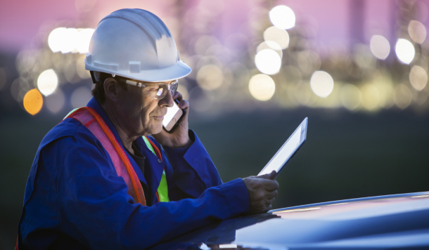 Construction worker uses two mobile devices
