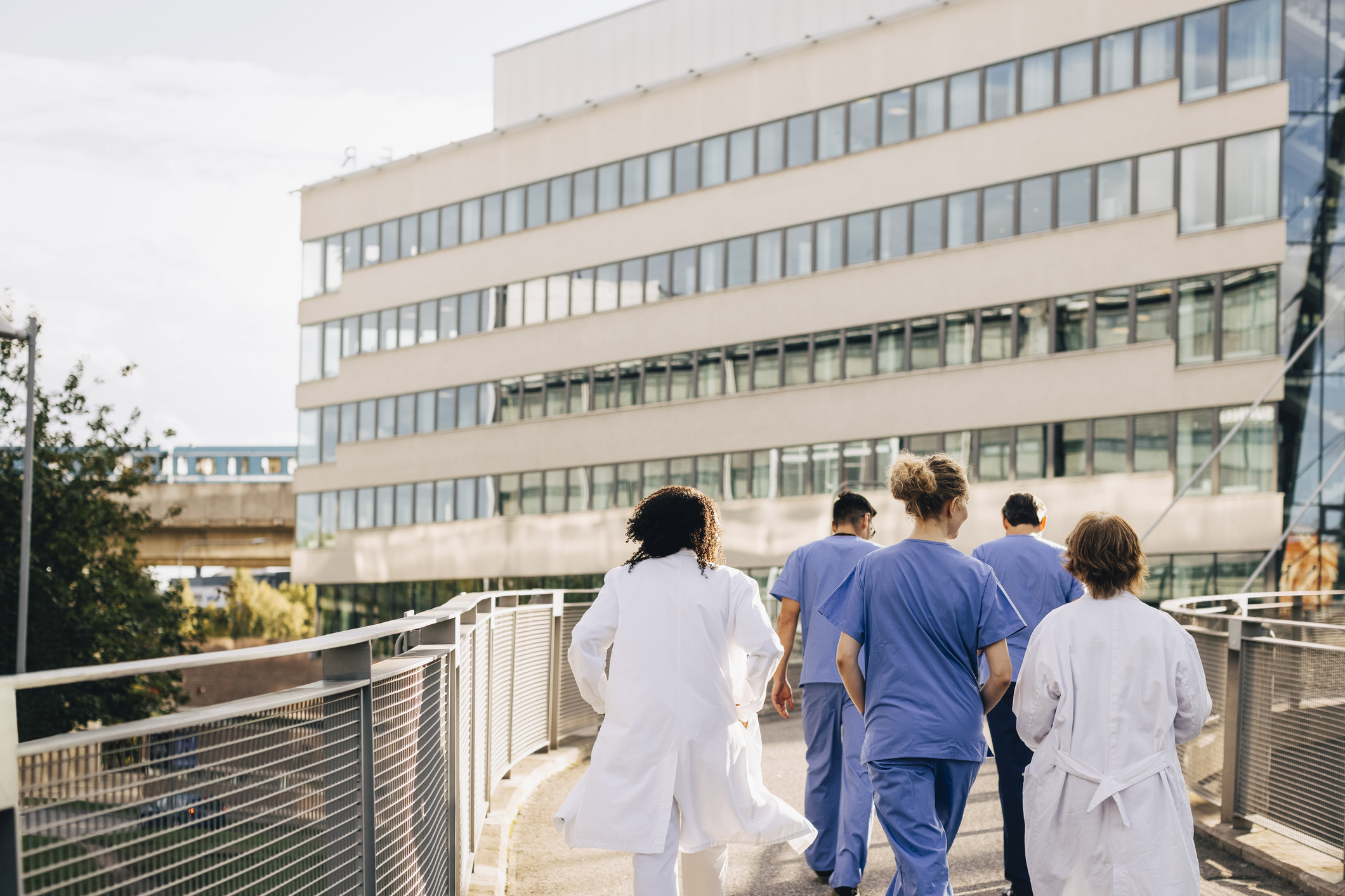 Group of healthcare professionals walking towards a hospital outside