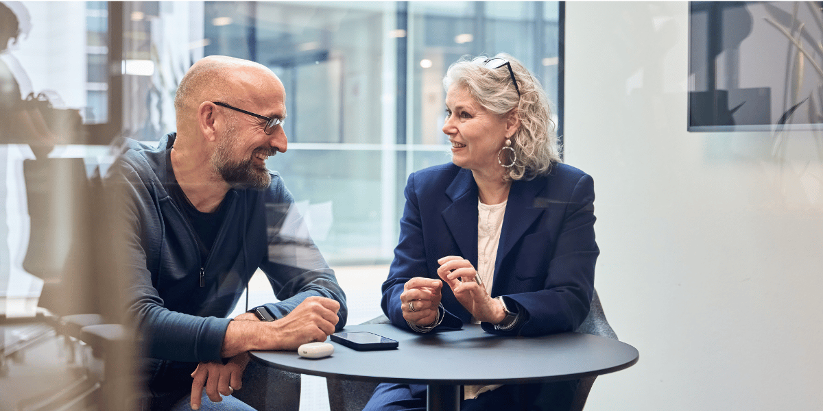 older man and woman talking at table