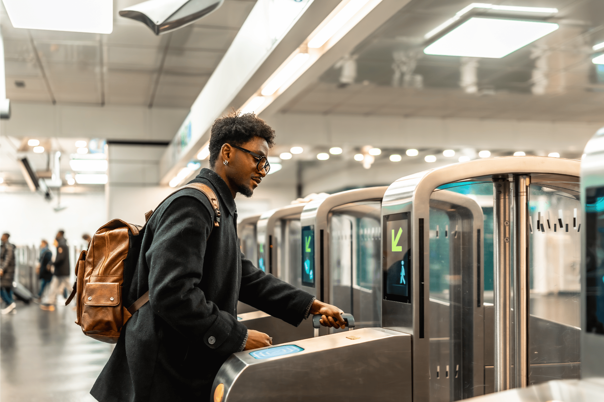 Man with a suitcase passing through a ticket door with a suitcase