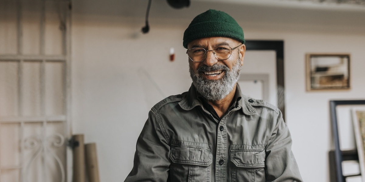 Man in green beanie smiling at camera