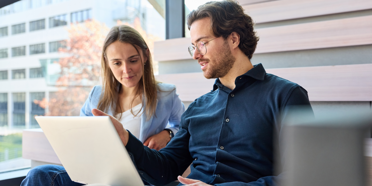 2 employees review T&E dashboard in the office