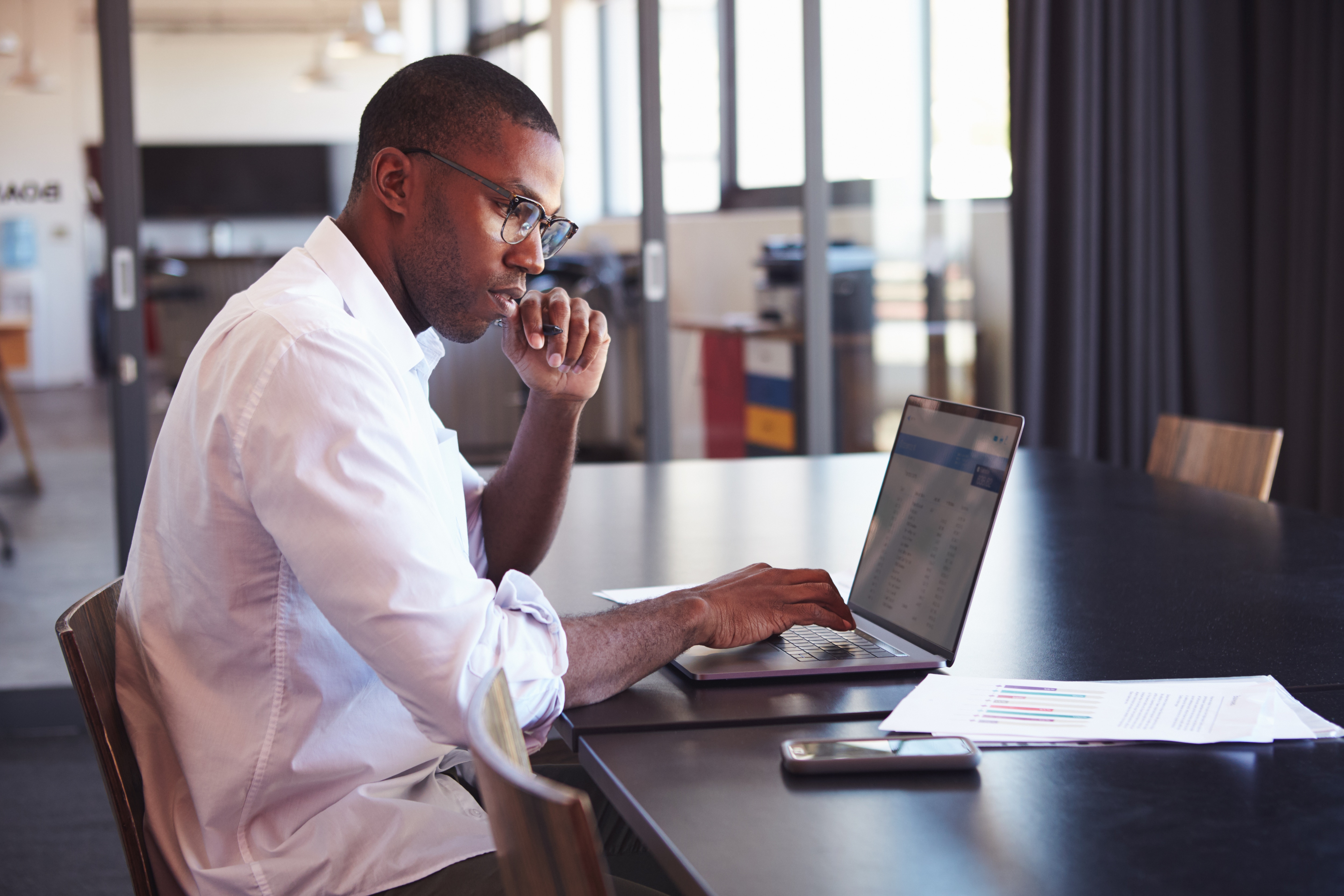 Man on computer in a meeting room