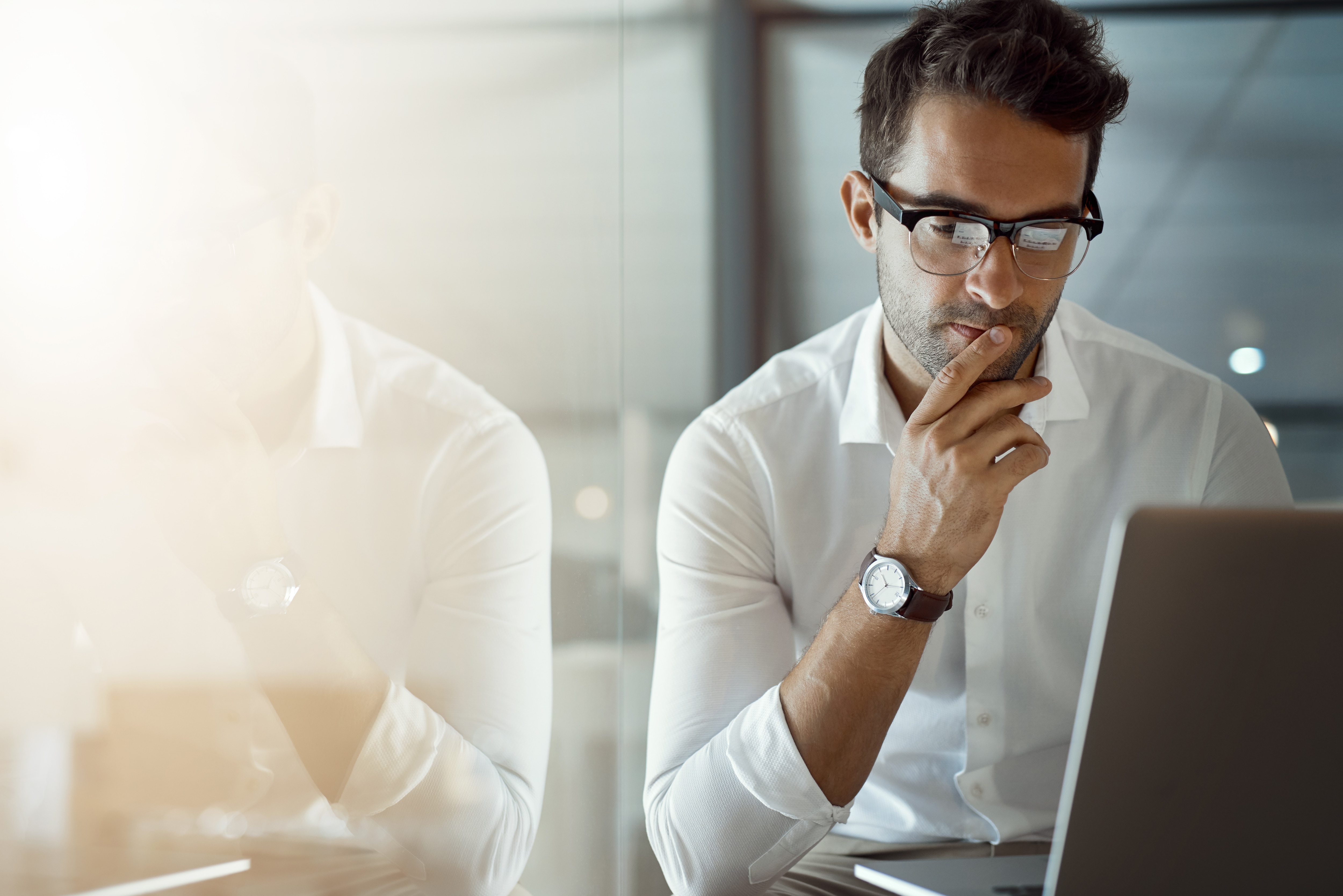 Man with glasses looking at computer