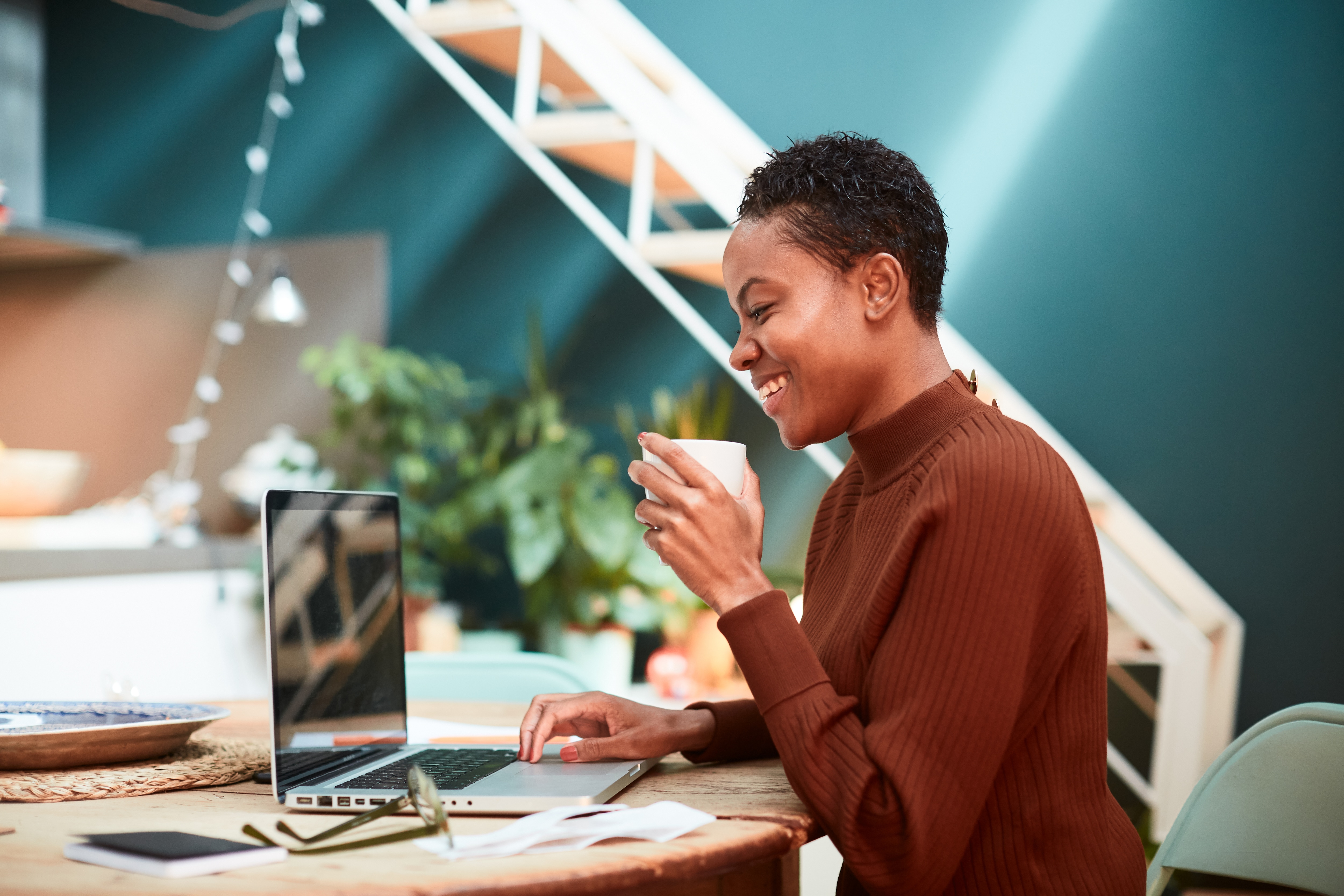 woman smiling while working on budget at computer