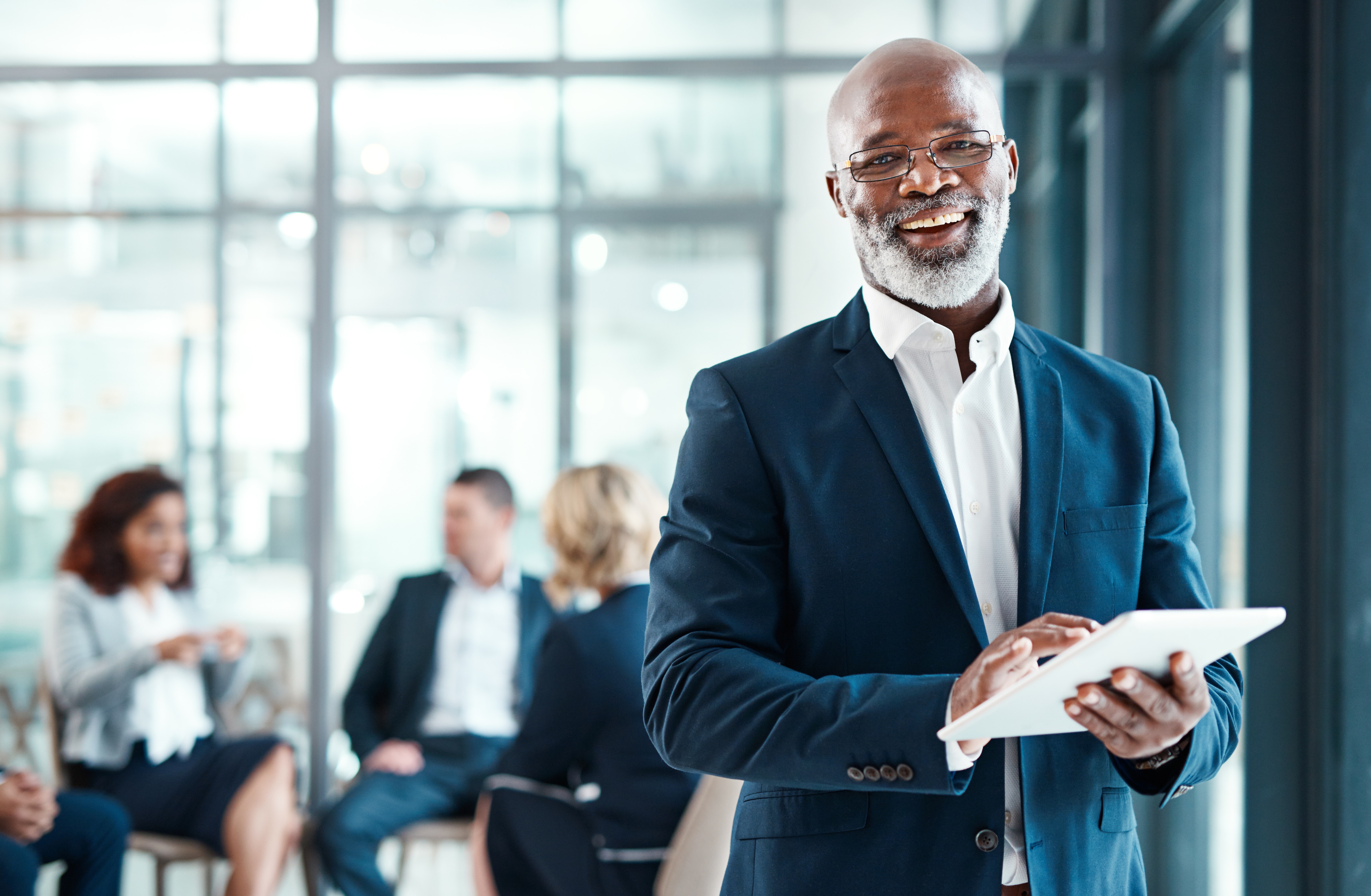 Financial services employee smiling with team in the background