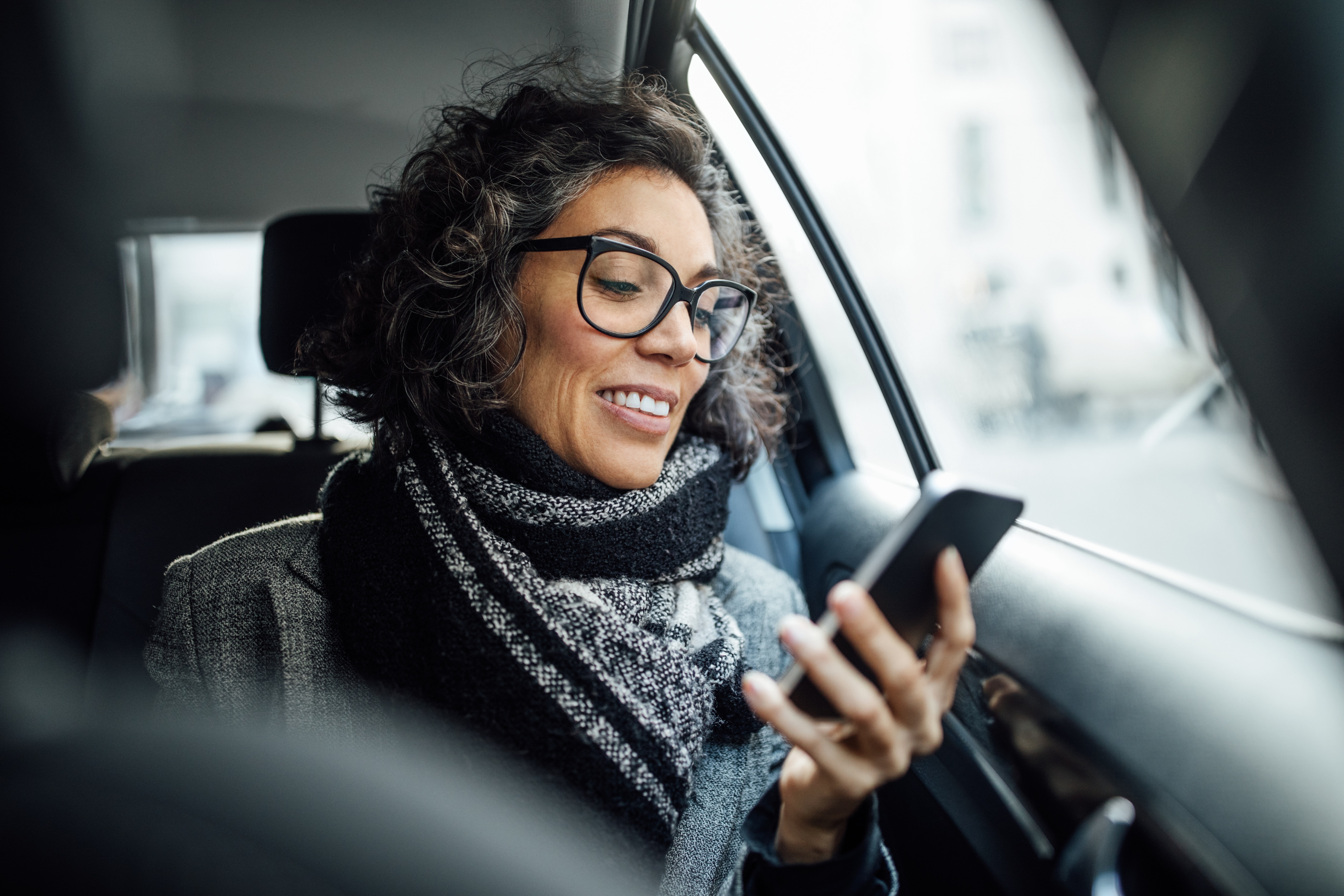 Woman in care looking at phone