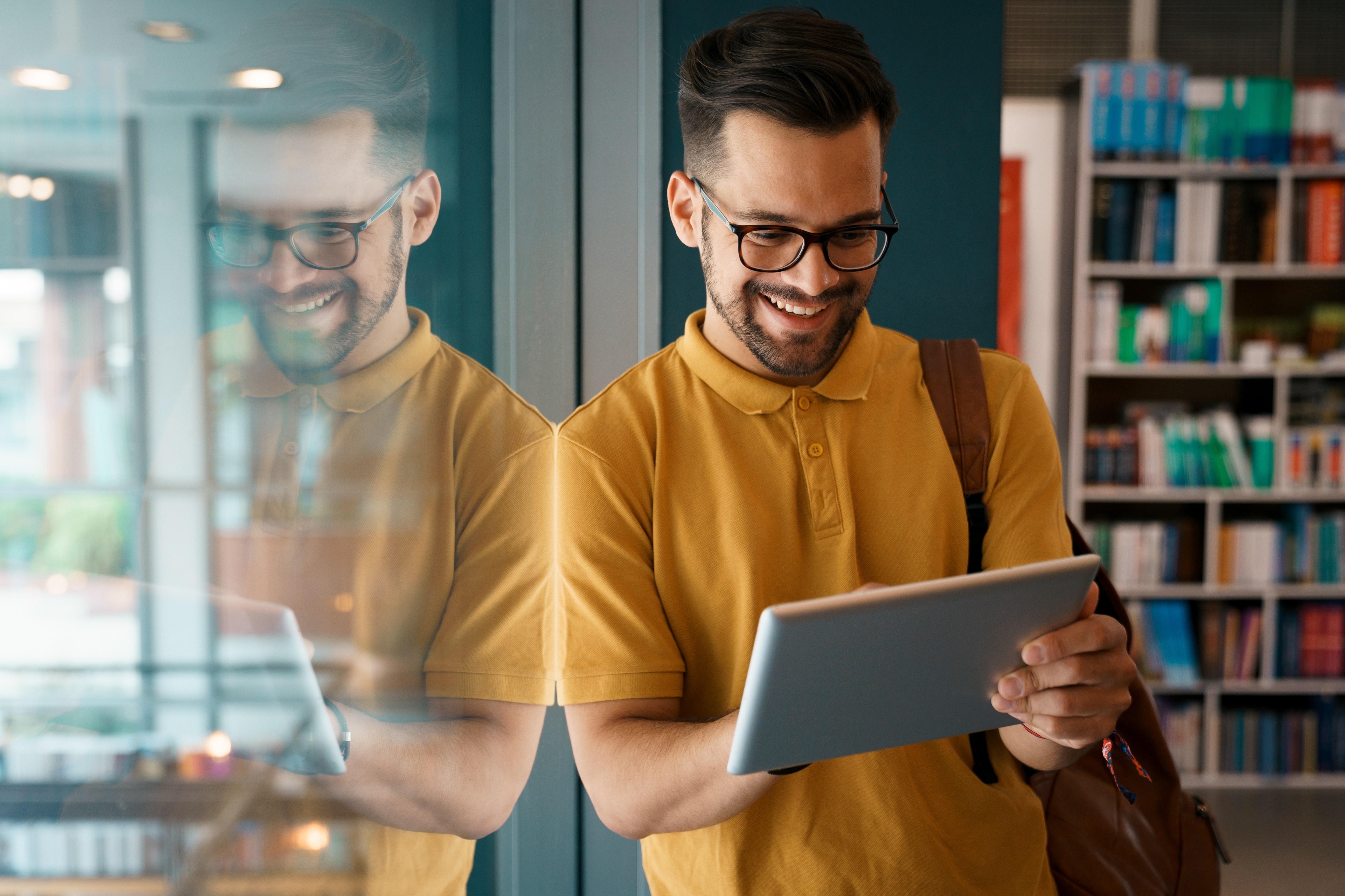 Man in library looking at tablet