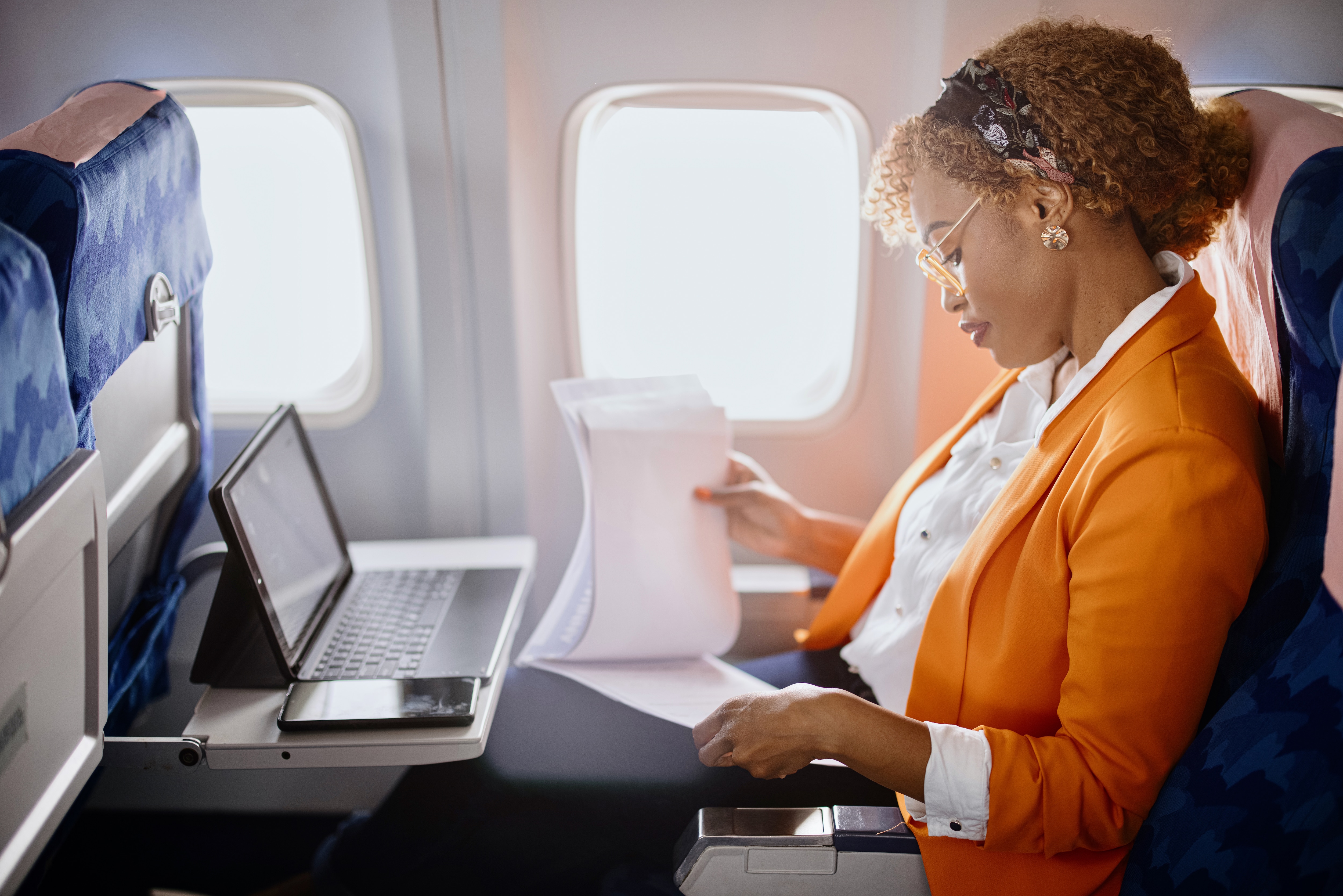Woman on a plane working on laptop
