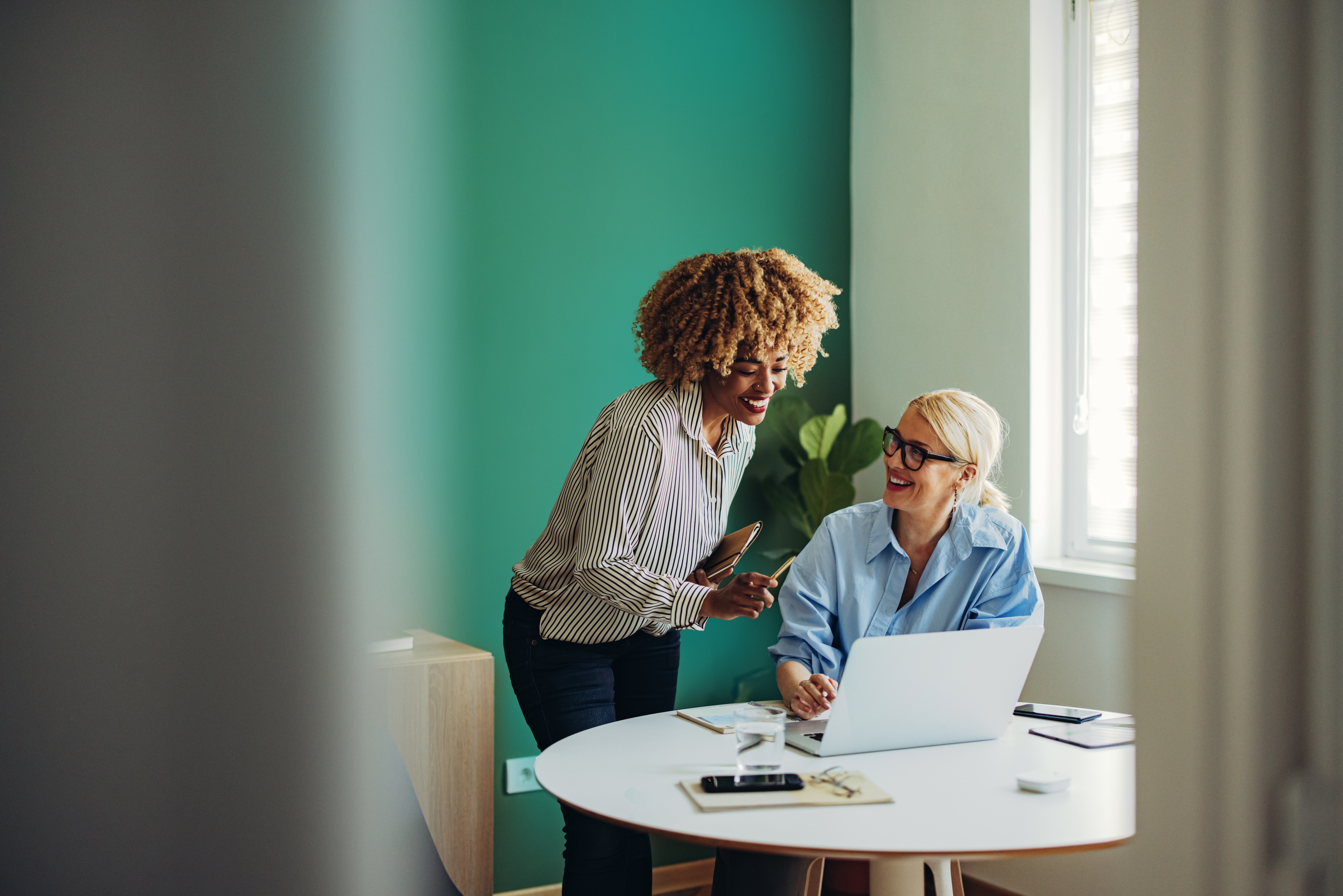 Two women looking at a laptop in an office