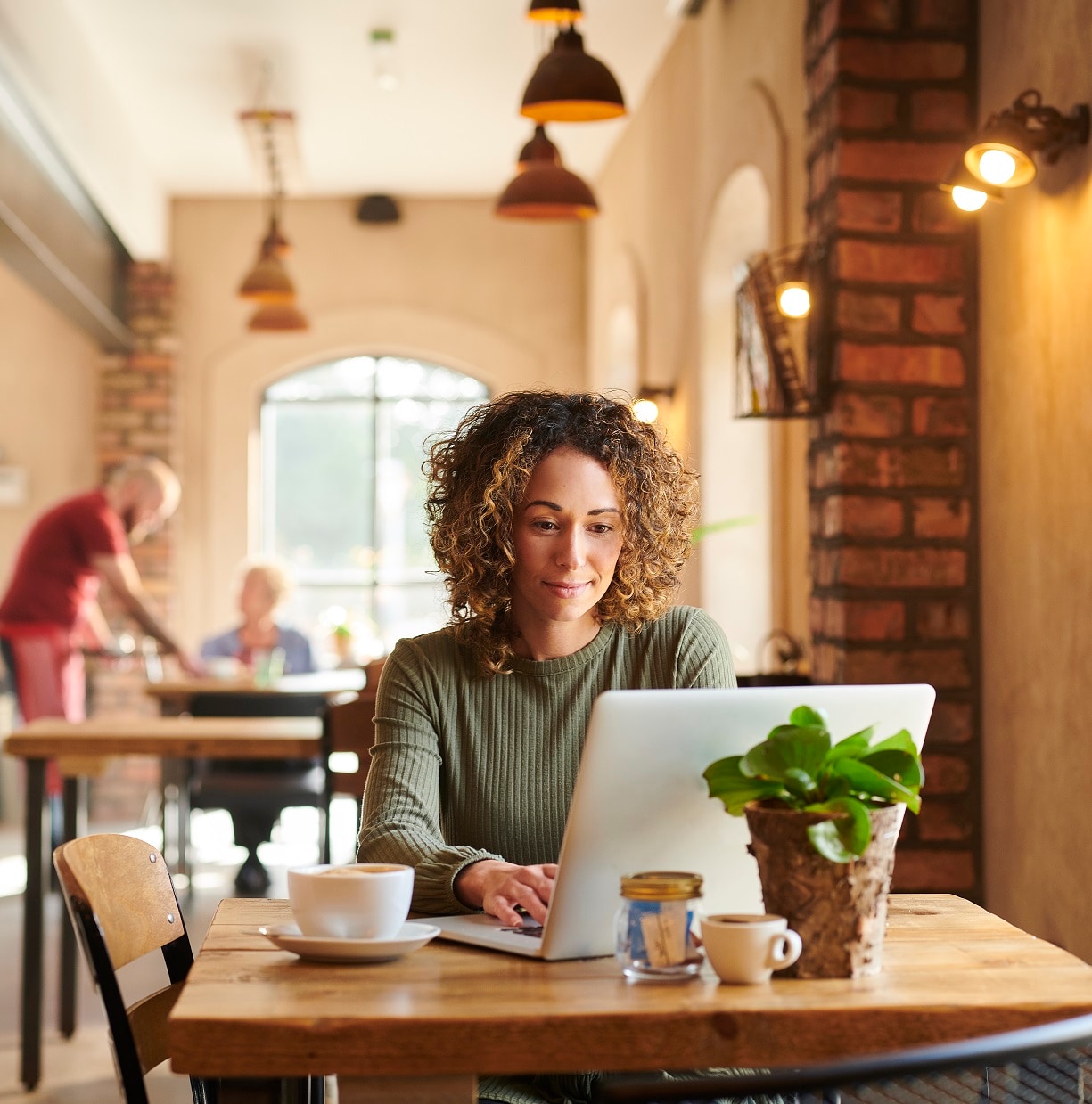 A person in a cafe working on a laptop computer
