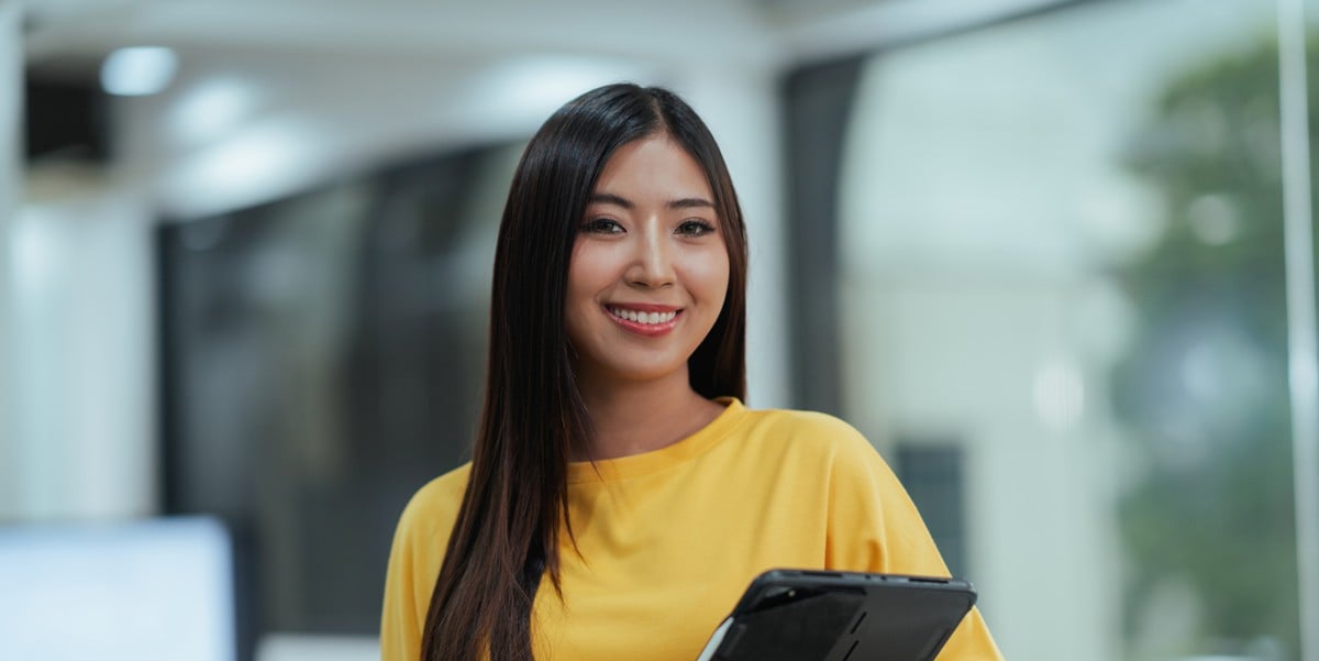 Woman holding tablet and smiling at camera