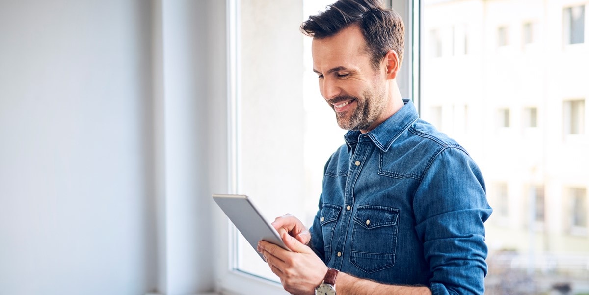 man alone looking at tablet in hand