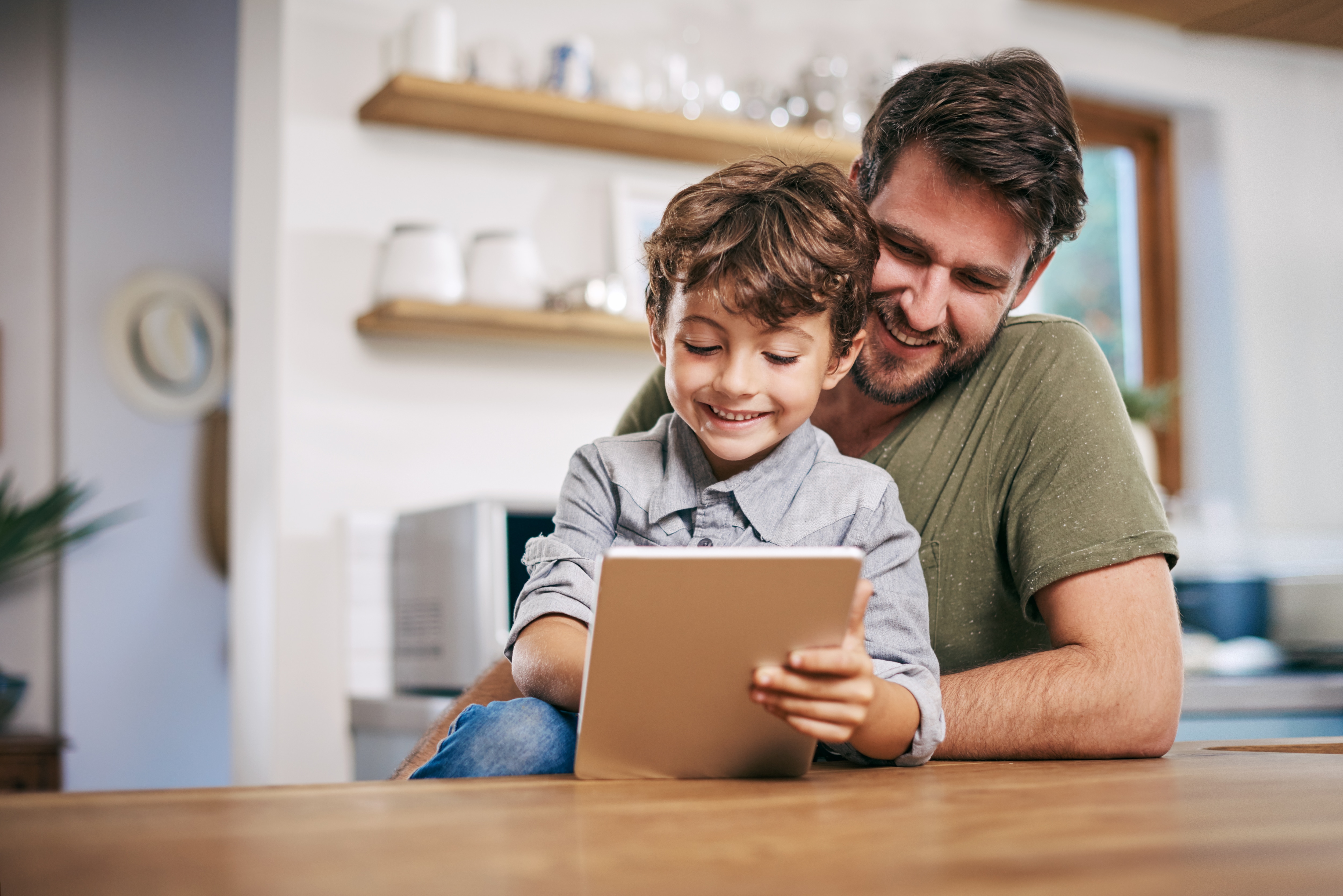Father helping son on iPad
