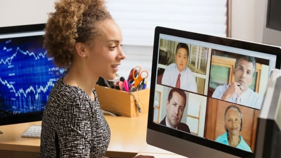 Woman at computer screen with faces on Zoom call