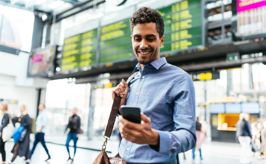 Man looking at phone in airport