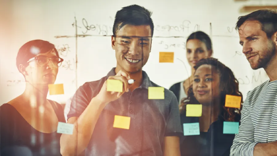 group of people working together on a whiteboard