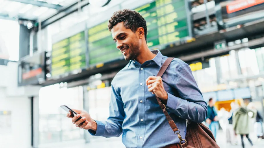 man looking at phone at airport