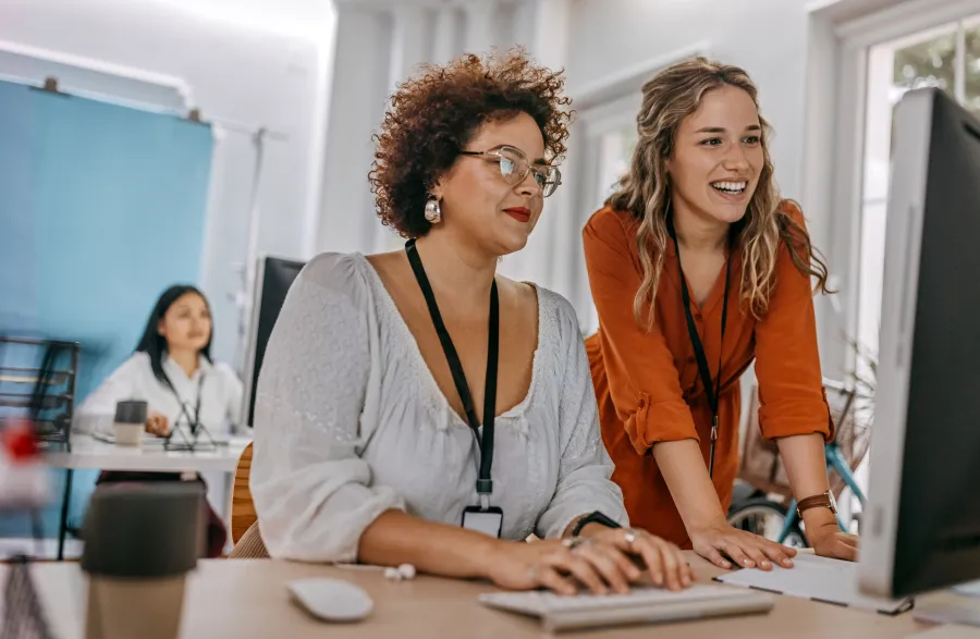 two women working on laptop