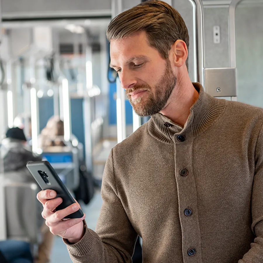 Man checking his smart phone on a train