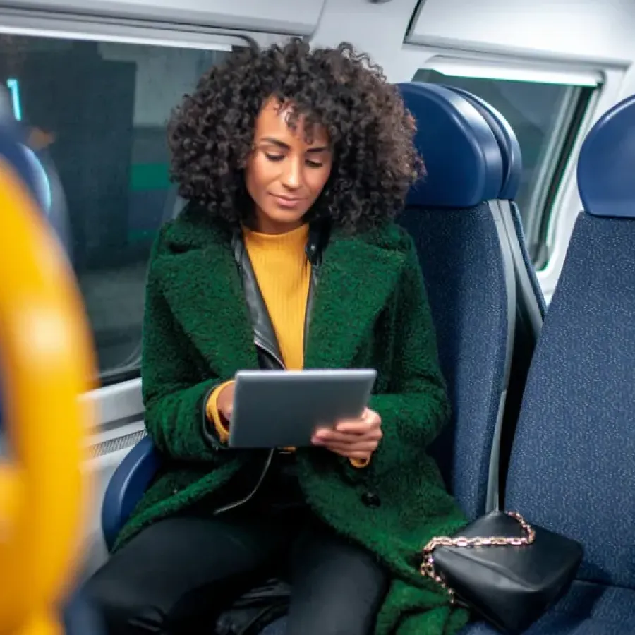 Business woman using a tablet while on a commuter train