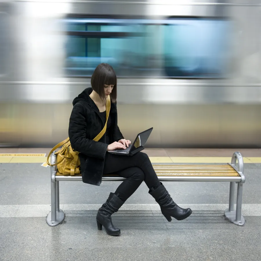 Woman uses a laptop in a subway station