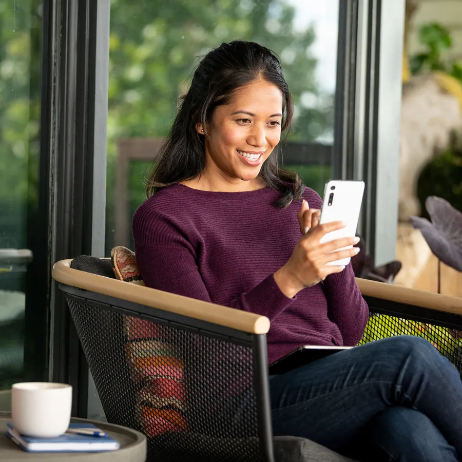 Woman sits outdoors using a smartphone