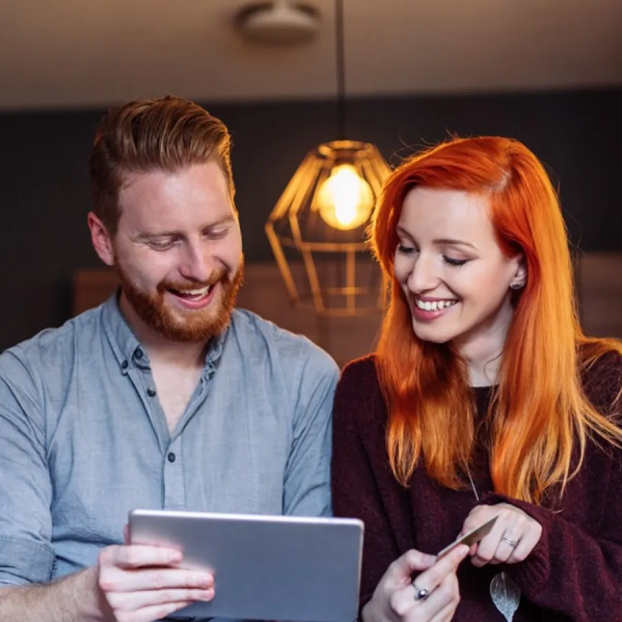 Smiling man and woman looking at a tablet