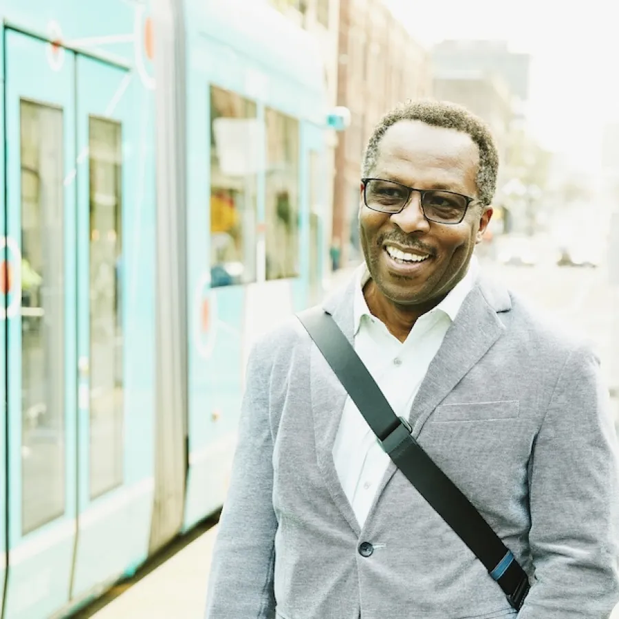 man standing outside a tram stop