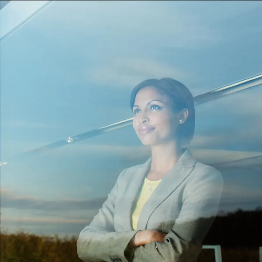 woman looking out campus window smiling