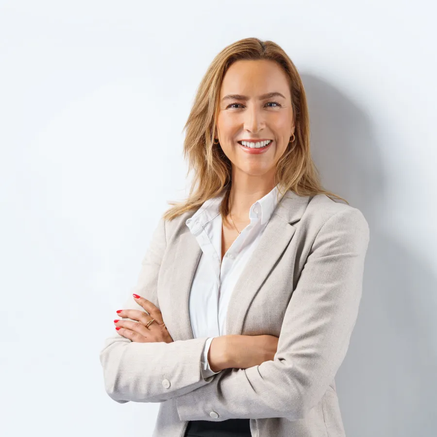 blonde woman smiling with arms crossed