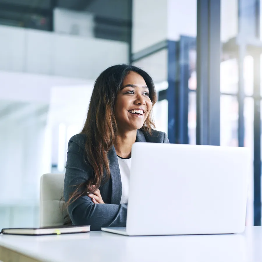 Woman smiling while working on laptop