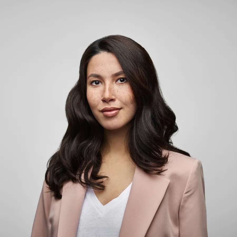 woman with dark hair in pink blazer