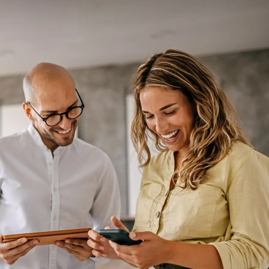 man and woman with tablet smiling