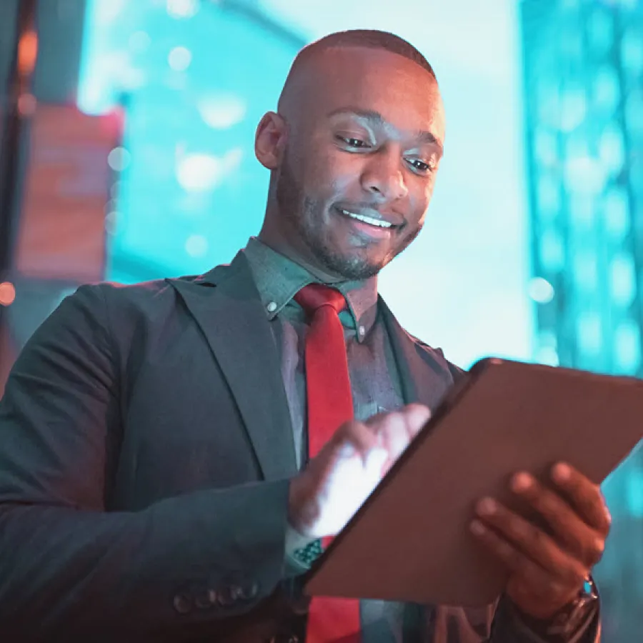 smiling man in suit looks at device