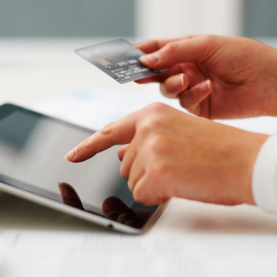 Credit card and ipad with two hands showing a purchase
