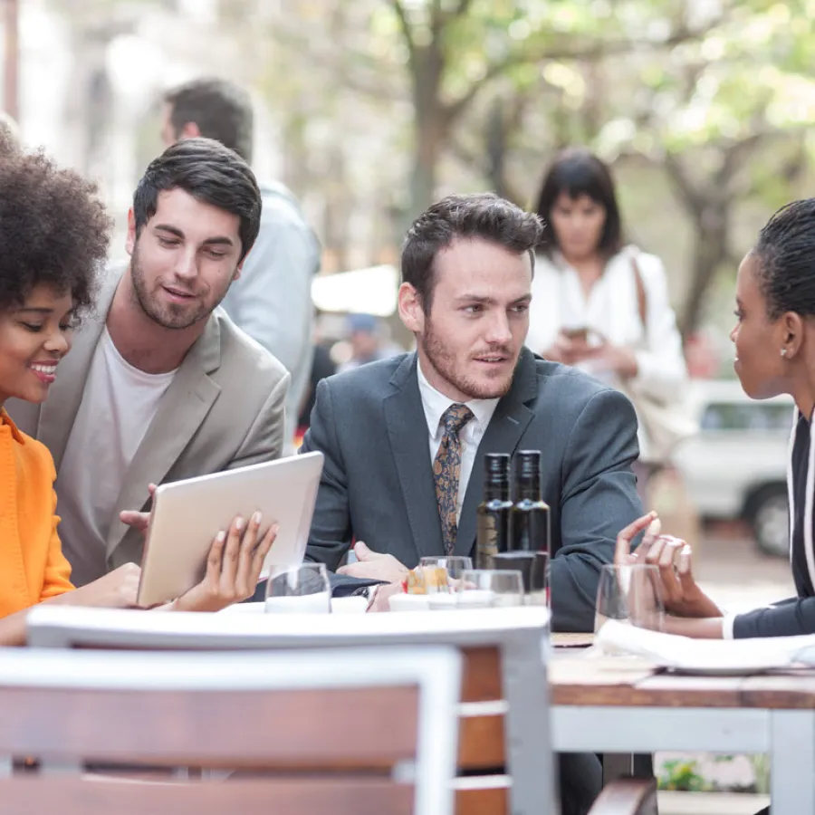 Young business people sitting at table outdoors