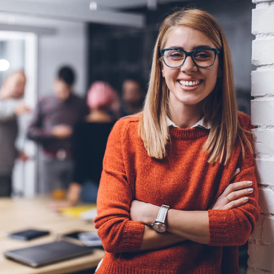 Smiling woman standing next to wall in office