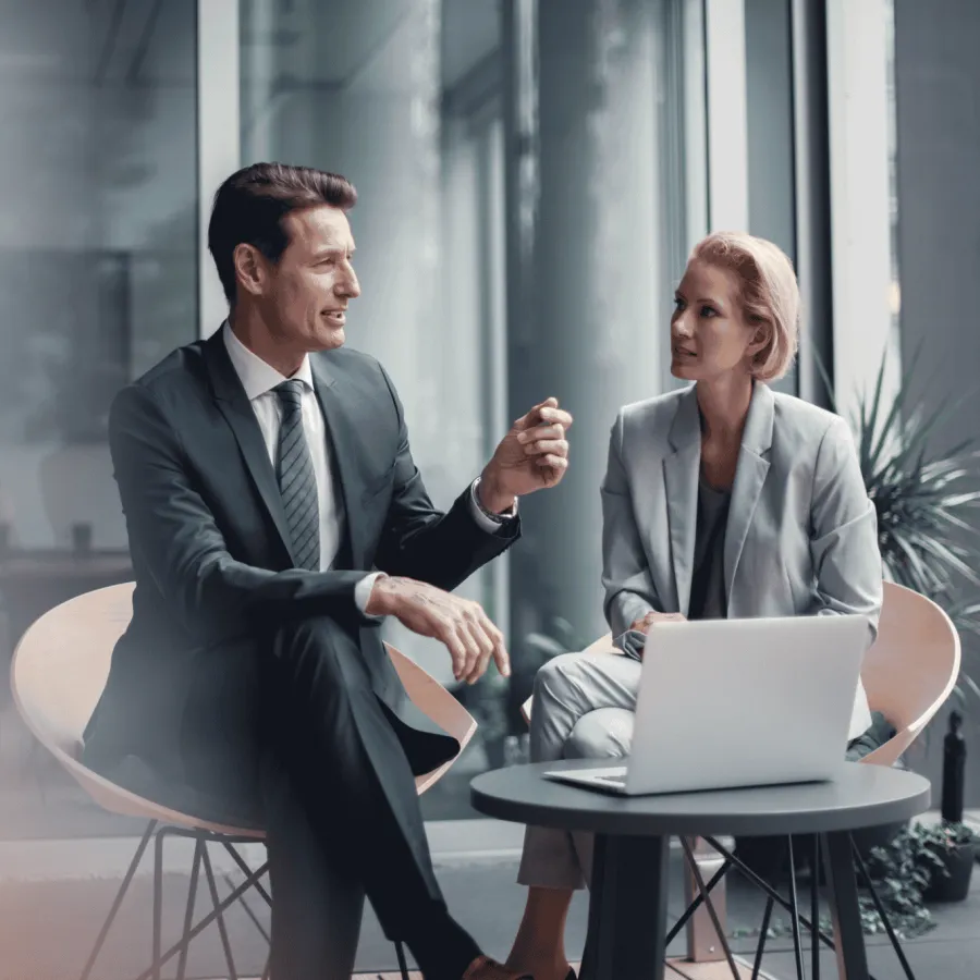 A man and a woman sitting at a table with a computer