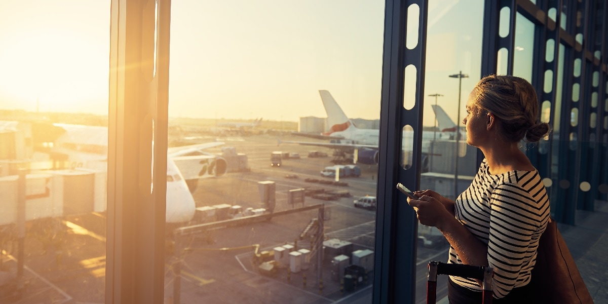 Woman at an airport looking out at the airplanes